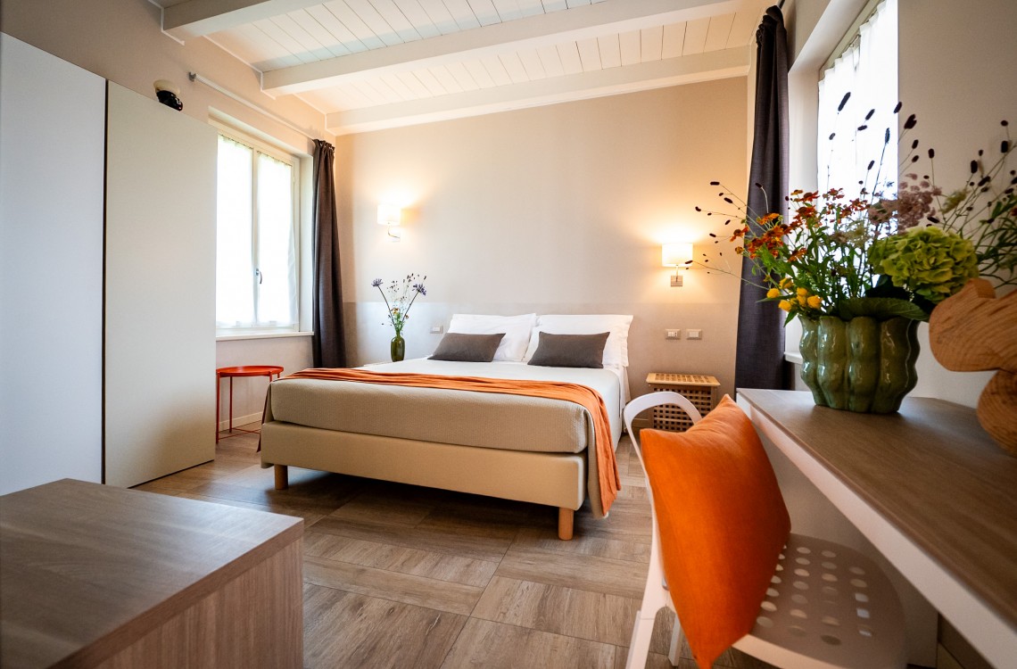 Disposta al piano primo dell'edificio che chiude l'antica corte, camera doppia ampia e luminosa è pensata per essere il luogo ideale dove trascorrere il vostro soggiorno di vacanza o di lavoro. Di complessivi 28 mq circa, è arredata con stile contemporaneo, caldo ed elegante, dispone di letto matrimoniale, scrivania e confort di ultima generazione. Gode ​​di una bellissima vista sugli edifici circostanti e sulla campagna.  <br>Con letto matrimoniale, disponibile uso SINGOLA e uso DOPPIA.