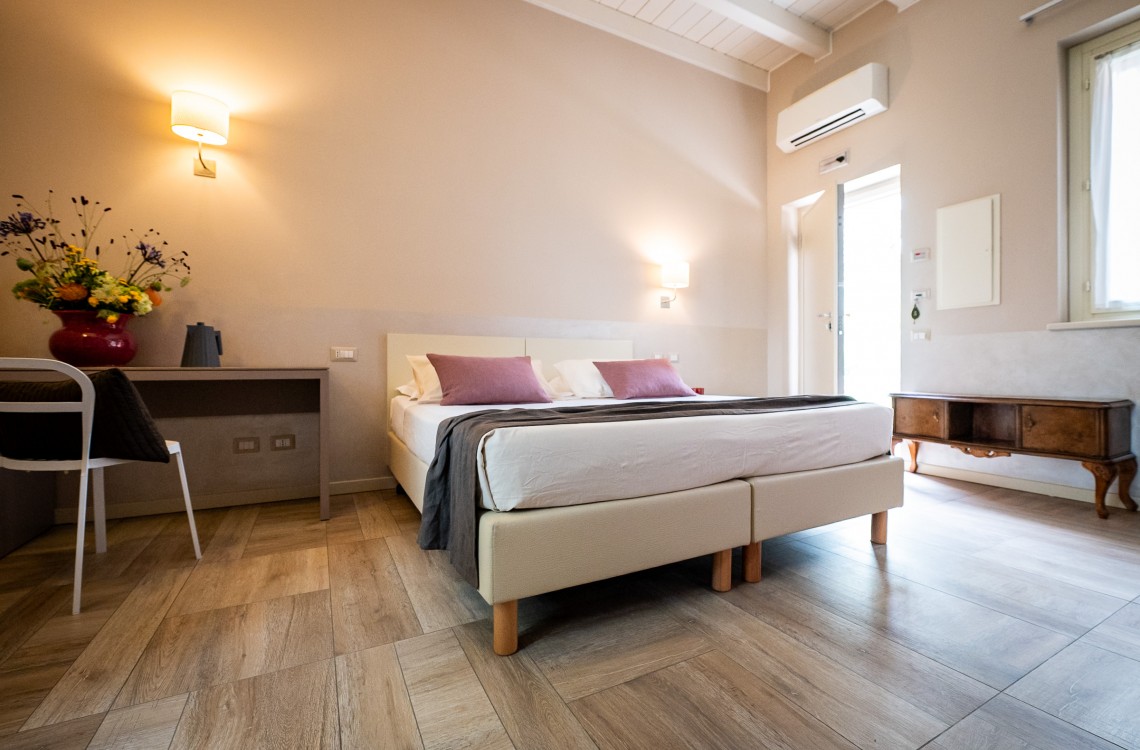 Disposta al piano terra dell'edificio che chiude l'antica corte, camera doppia, anche ad uso singolo, ampia e luminosa è stata pensata per essere il luogo ideale dove trascorrere il vostro soggiorno di vacanza o di lavoro. Possibilità di letto matrimoniale o due letti singoli. Di complessivi 30 mq circa, è arredato con stile contemporaneo, caldo ed elegante, dispone di scrivania e confort di ultima generazione. Gode ​​di una bellissima vista sugli edifici circostanti e sulla campagna. <br>Con letto matrimoniale o due letti singoli, disponibile uso SINGOLA e uso DOPPIA<br>